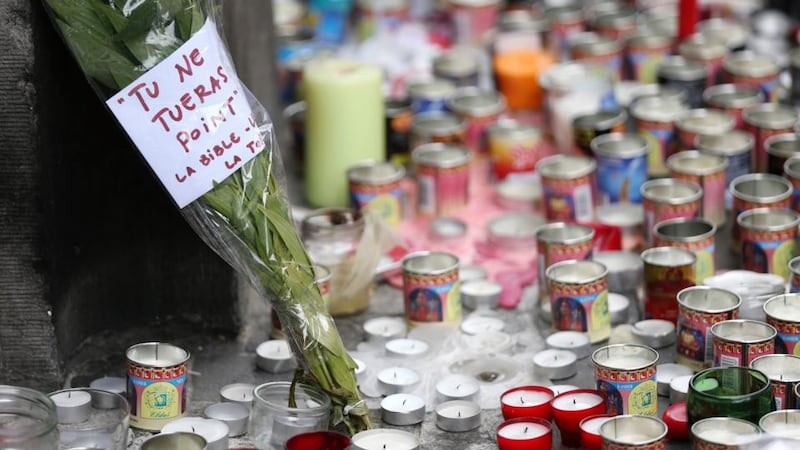 Flowers bearing the words, ‘Thou shalt not kill’ are set amid candles outside the Jewish Museum in Brussels. Photograph: Reuters