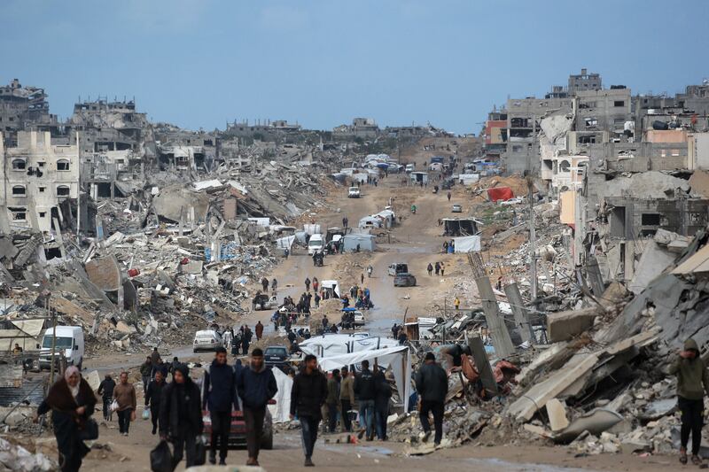 Displaced Palestinians walk through a muddy road this week amid the destruction in Jabalia in the northern Gaza Strip. Photograph: Bashar Taleb/AFP via Getty Images