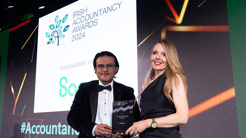 Mayank Pandya, chief executive, Pinnacle Global Group, presents the transformation project of the year award to Deirdre O'Keefe, Clever Burdy