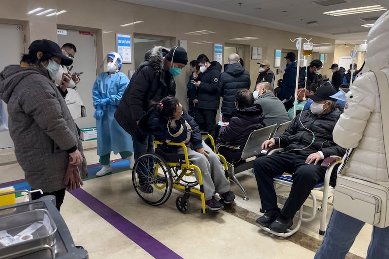 A man pushes his relative in a wheelchair as patients receive intravenous drips in the emergency ward of a hospital in Beijing. Photograph: Andy Wong/AP