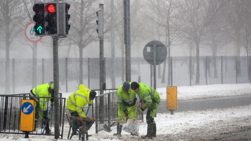 Workers clear and grit paths in Blanchardstown on Thursday afternoon. Photograph: Colin Keegan/Collins