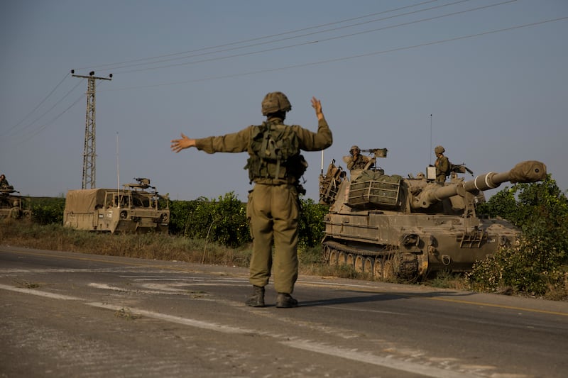 An Israeli soldier directs armoured vehicles heading towards the southern border with the Gaza strip  in Sderot, Israel. Photograph: Amir Levy/Getty Images