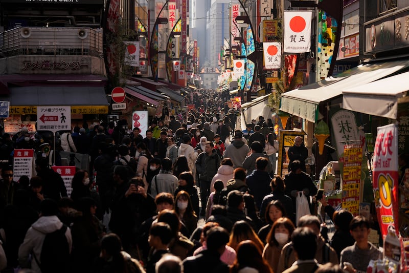 People thronged the Ameyoko shopping street in Tokyo on New Year’s Eve (Hiro Komae/AP)