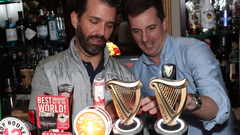 Donald Trump jnr (left) pours drinks and meets locals in the village of Doonbeg. Photograph:  Niall Carson/PA Wire