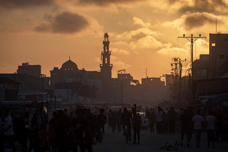 Palestinians walk at sunset in a destroyed street in Khan Yunis refugee camp, southern Gaza Strip. Photograph: Haitham Imad/EPA