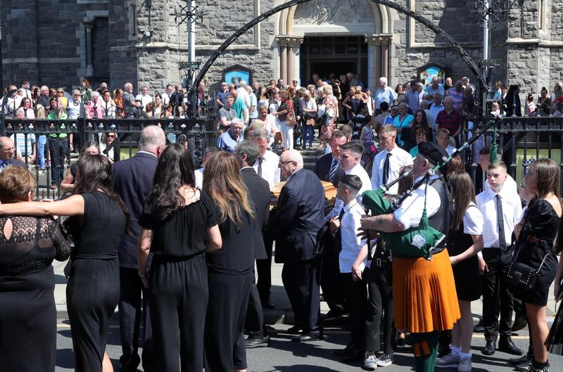 A piper plays as the remains of John Hutch are carried from the Church of the Holy Family, Aughrim Street this morning after his funeral mass. Photograph: Colin Keegan/Collins Dublin