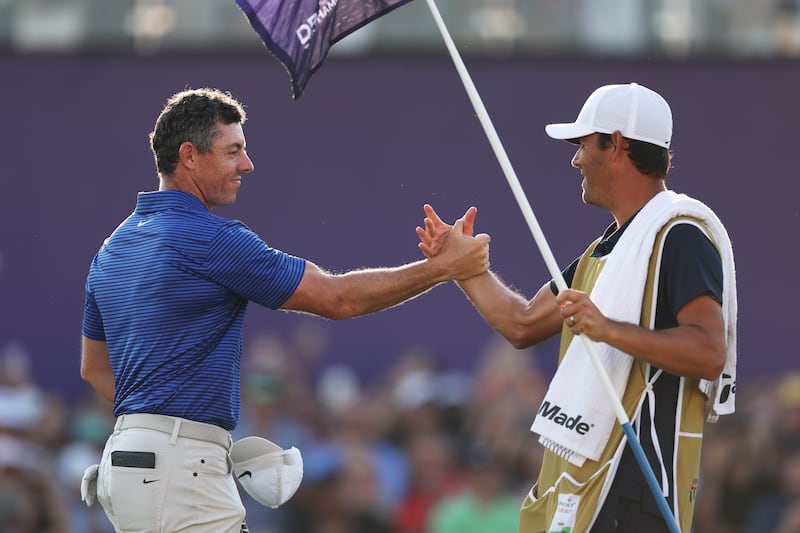 Rory McIlroy of Northern Ireland shakes hands with his caddie, Harry Diamond on the 18th green. Photograph: Richard Heathcote/Getty