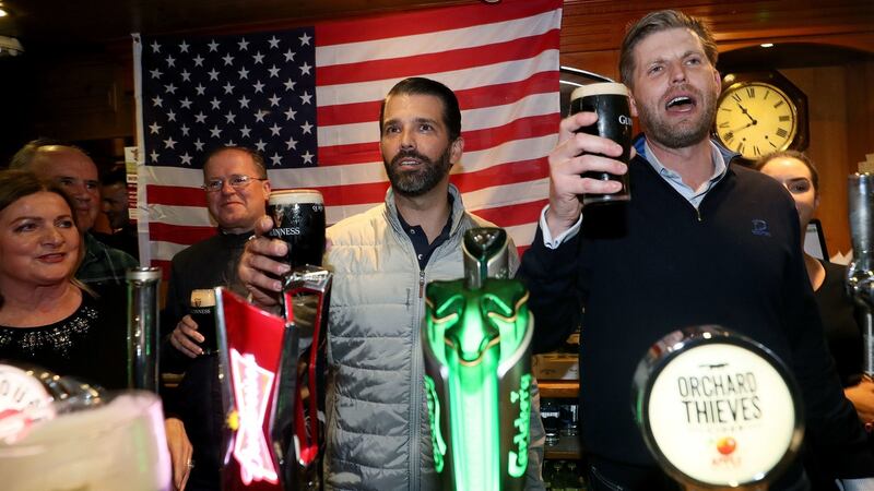 Donald Trump jnr (centre), and Eric Trump (right) behind the bar in Tubridy’s Bar in the village of Doonbeg, Co Clare. Photograph:  Brian Lawless/PA Wire