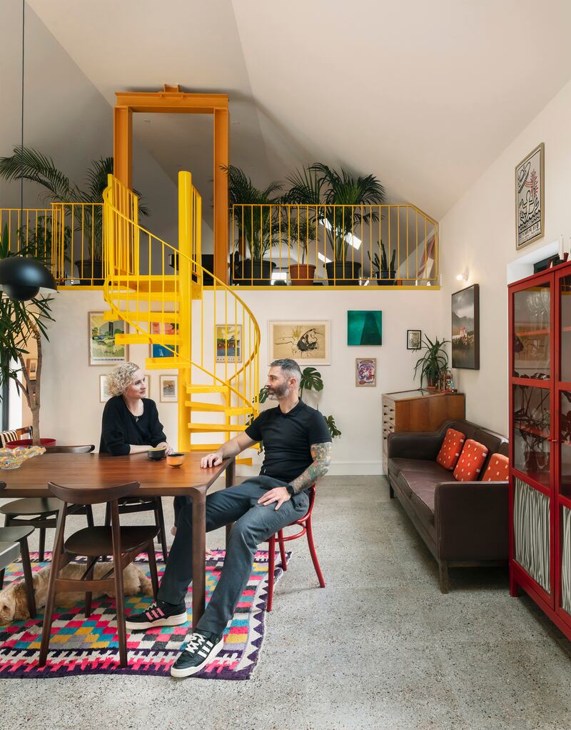 Eamonn and Liz in their kitchen with mezzanine level behind. 'If a staircase was going to take up half a wall, it had to become a feature and make if fun,' was Eamonn’s point of view. The spiral stairs and mezzanine were powdercoated in blackbird beak yellow by Stainless Steel Solutions in Co Kilkenny