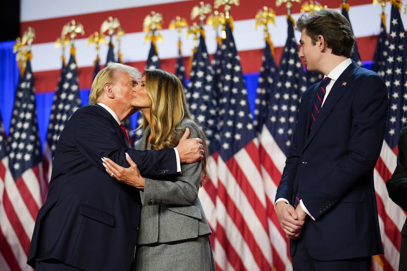 Donald Trump kisses Melania Trump as his son Barron Trump looks on in the Palm Beach County Convention Center in West Palm Beach, Florida. Photograph: Doug Mills/The New York Times
                      