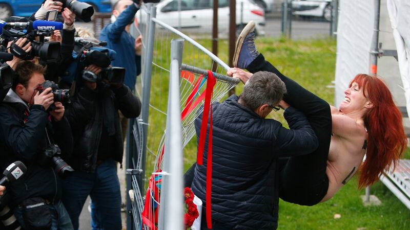 An activist is led away by police after activists lowered a banner protesting against Marine Le Pen’s FN party in Henin-beaumont, northern France on Sunday.