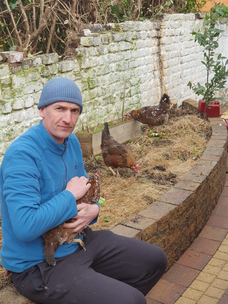 Barry Bryan holding his hen Molly, with Babsy and Bunty in the background