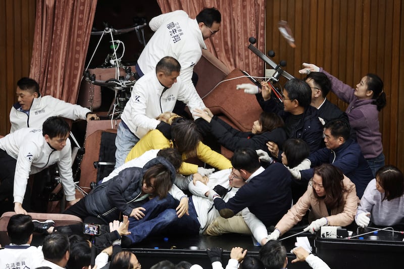 Lawmakers from the main opposition Kuomintang (KMT) (in white) try to break into Parliament where Democratic Progressive Party (DPP) occupied the night to avoid the passing of the third reading of amendments to the Civil Servants Election and Recall Act and other controversial bills at the Legislative Yuan in Taipei. Photograph: I-Hwa Cheng/AFP