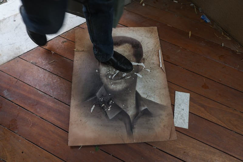 A man treads on a picture of Syria's ousted president Bashar al-Assad as people enter his residence in Damascus' al-Maliki area. Photograph: Omar Haj Kadour/AFP/Getty Images