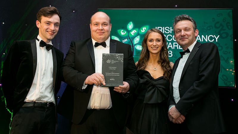 Carl Churchill, Managing Director, NetPay Solutions Group presents the CSR Initiative of the Year Award to Sadbh McCarrick, John Mc Carrick and Conn Mc Carrick, John McCarrick & Associate