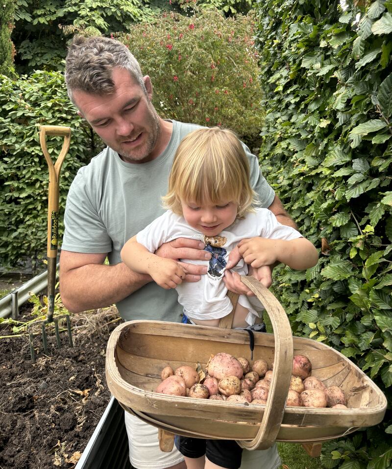 Peter O'Mahony and his son picking potatoes from the garden