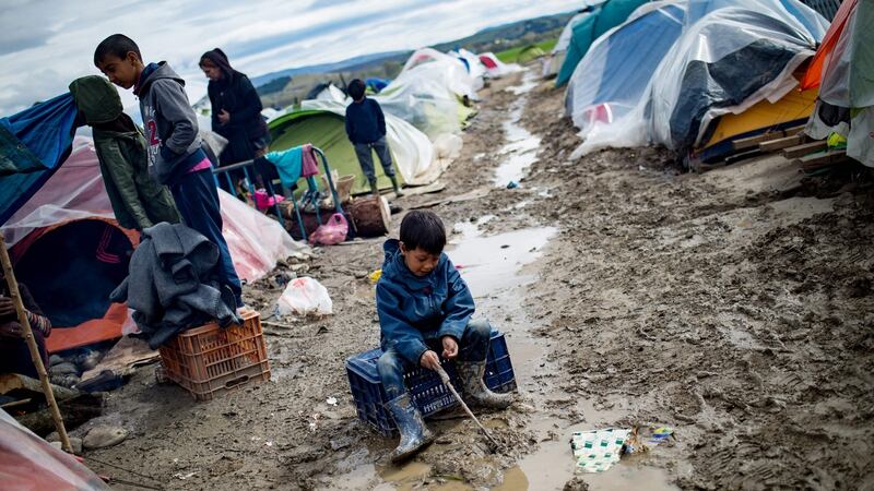 A boy plays in a puddle at a makeshift camp occupied by migrants and refugees at the Greek-Macedonian border. Photograph: Andrej Isakovic/AFP/Getty Images