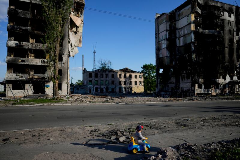 A boy plays in front of houses ruined by shelling in Borodyanka. Photograph: AP