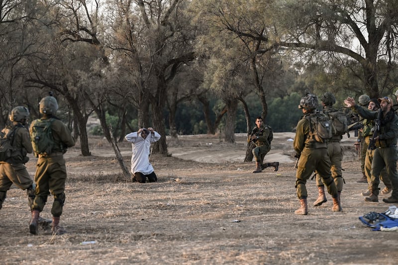 Israeli soldiers detain a man while on patrol near Kibbutz Beeri, the place where hundreds of revellers were killed by Hamas militants during the Supernova music festival. Photograph: Aris Messinis/AFP via Getty Images