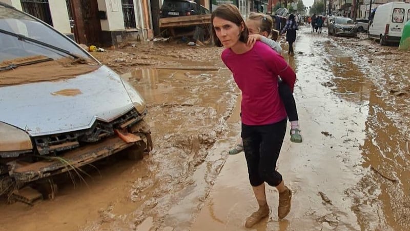 Christine Connolly carrying her four-year-old daughter Yasmin through the floods in Massanassa near Valencia