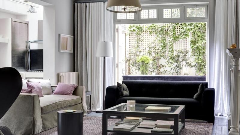 A bronze floor lamp and square coffee table are key components of the sitting room. Photograph: Luke White