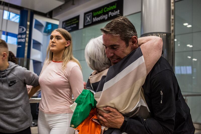 Jason Black arrives in Dublin Airport one week after summiting K2 in Pakistan to a hug from his mother-in-law Una with his son Billy and his daughter Kate in the background. Photo: James Forde/The Irish Times