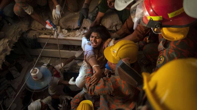 Rescue workers rescue a garment worker from the rubble of the collapsed Rana Plaza building, in Savar outside Dhaka yesterday. Photograph: Reuters