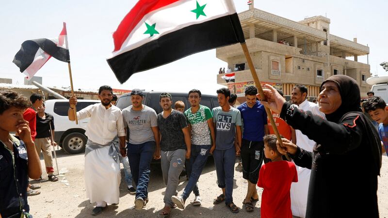 A woman holds a Syrian flag in Deraa, where the uprising against Bashar al-Assad’s regime began in 2011. Photograph: Omar Sanadiki/Reuters