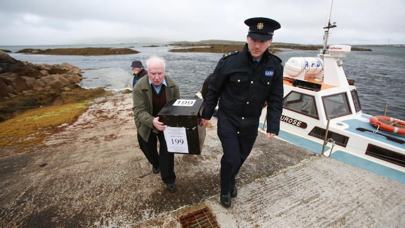 Presiding officer Hugh O’Donnell (left) and Garda officer P.J. McHugh carry the ballot box to the island of Innishfree, Co Donegal. Photograph: Paul McErlane/EPA