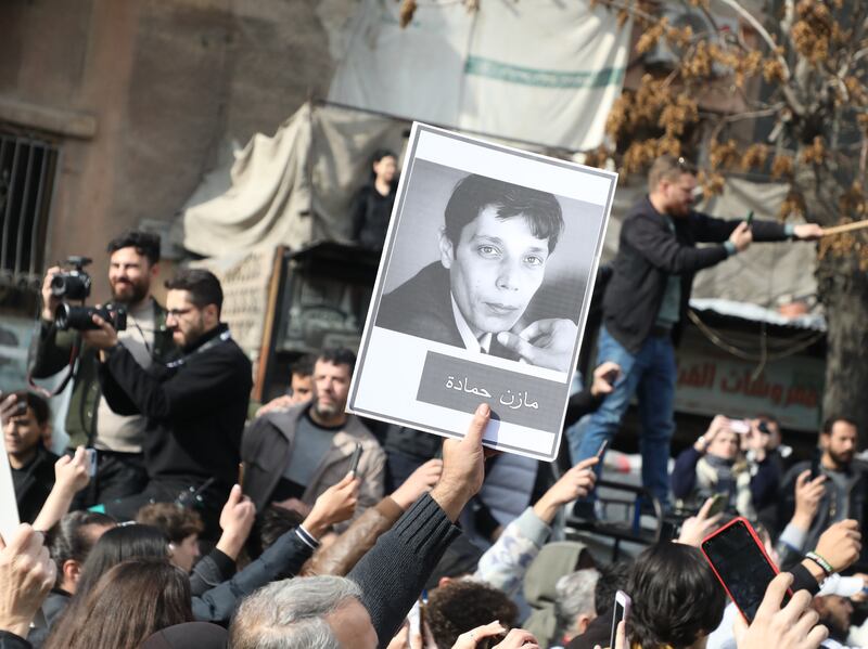 A photograph  of activist Mazen Hamada is held up during his funeral on December 12th, 2024, in Damascus, Syria. Photograph: Ali Haj Suleiman/Getty 