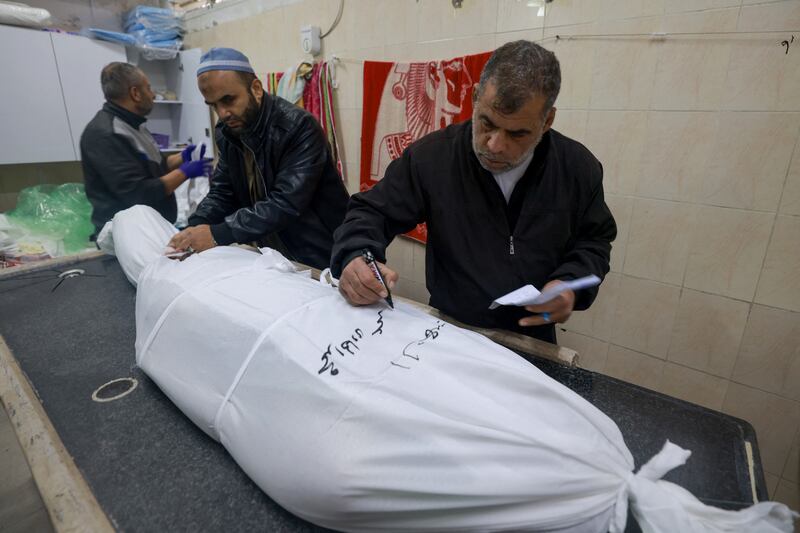 Medics write the name on a person killed following Israeli bombardment at al-Najjar hospital. Photograph: Mohammed Abed/AFP/Getty Images