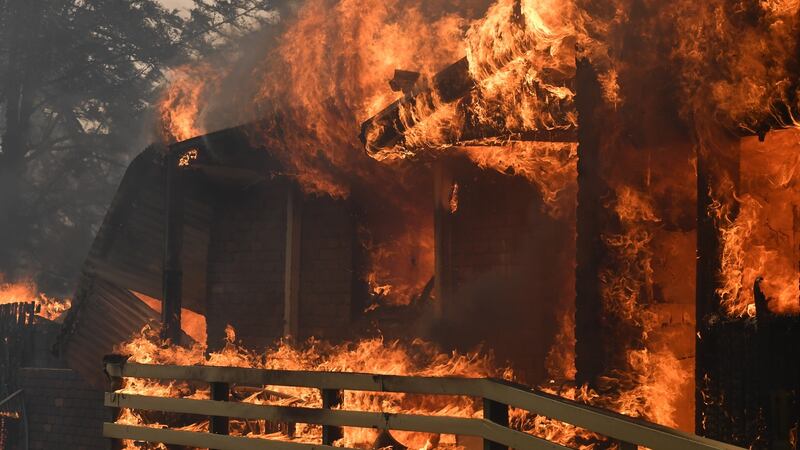 Fire burns a home in Buxton, New South Wales.  Photograph: EPA