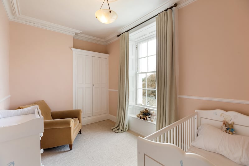 Children's bedroom with Victorian sash window and ornate cornicing.