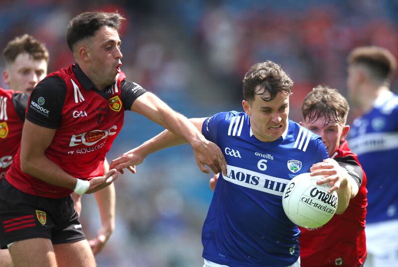 Down’s Ryan Johnston and Micheal Rooney tackle Brian Byrne of Laois. Photograph: Leah Scholes/Inpho