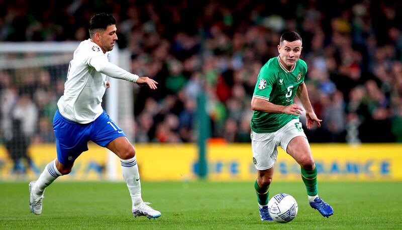 Josh Cullen and Tasos Bakasetas of Greece during their Euro 2024 qualifying game at the Aviva Stadium on Friday. Photograph: Ryan Byrne/Inpho