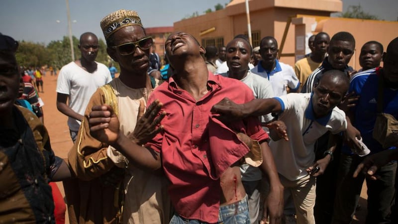 People comfort an anti-government protester who was shot in Burkina Faso capital Ouagadougou during today’s clashes. Photograph: Joe Penney/Reuters