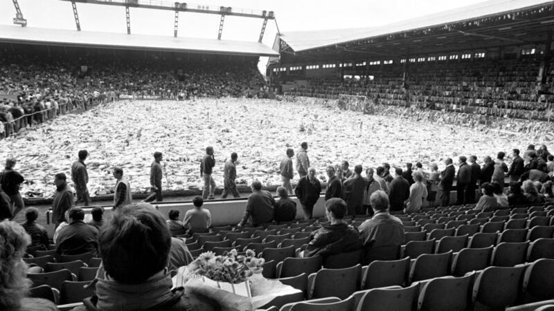 Thousands of fans, friends and family gather around a pitch full of flowers at Anfield for a ceremony of remembrance in April 1989.  Photograph: PA