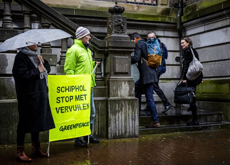 Climate activists hold a sign that reads "Schiphol stop polluting" outside a court hearing a case against the Dutch government over plans to limit flights at Amsterdam's Schiphol Airport for environmental reasons. Photograph: Remko de Waal/ANP/AFP via Getty Images