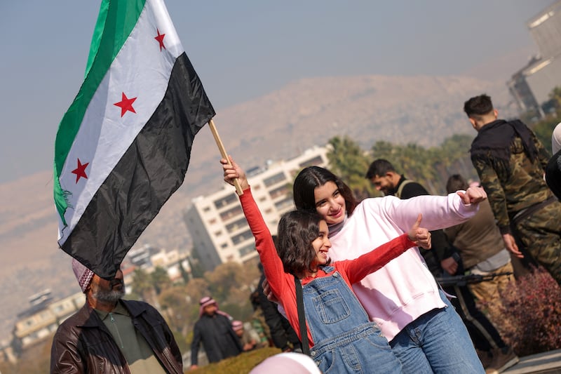 A girl poses for photos waving a Syrian opposition flag at Umayyad Square in Damascus. (Photograph: Omar Haj Kadour/AFP/Getty Images