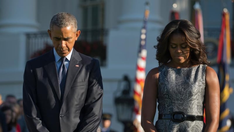 US president Barack Obama and first lady Michelle Obama with White House staff during a memorial ceremony marking the 14th anniversary of the September 11th terror attacks at the White House in Washington. Photograph: Stephen Crowley/The New York Times.