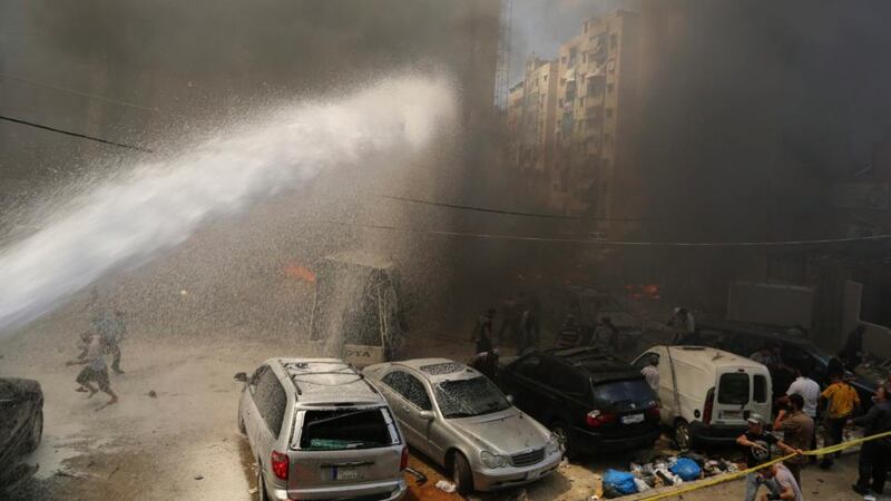 Emergency services extinguish fire at the site of the explosion. Photograph: Issam Kobeisi/Reuters