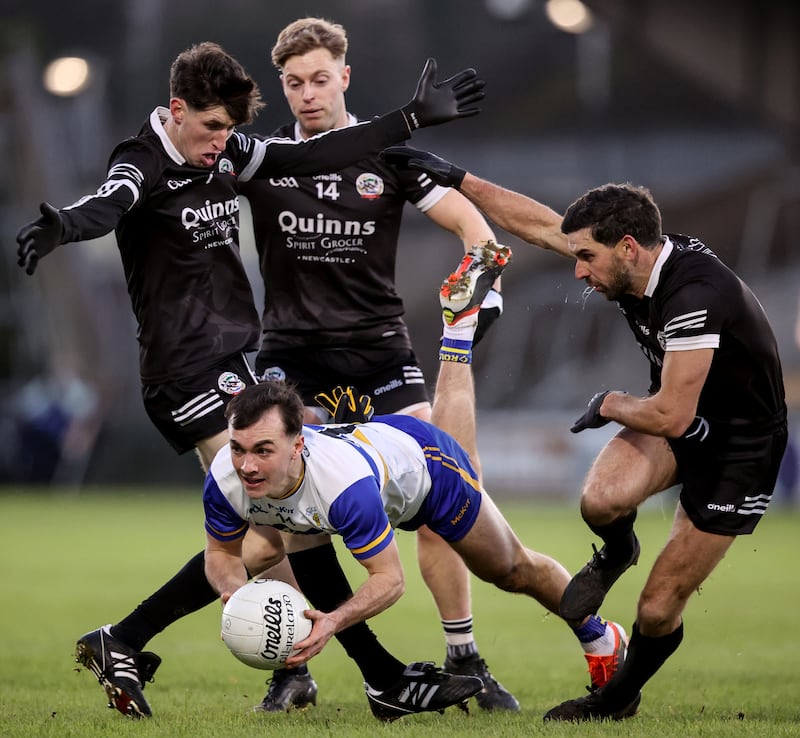 Darragh Canavan is tackled by Kilcoo's Eugene Branagan, Jerome Johnston and Niall Branagan in the Ulster senior club championship final in Armagh in December.  Photograph: Ben Brady/Inpho