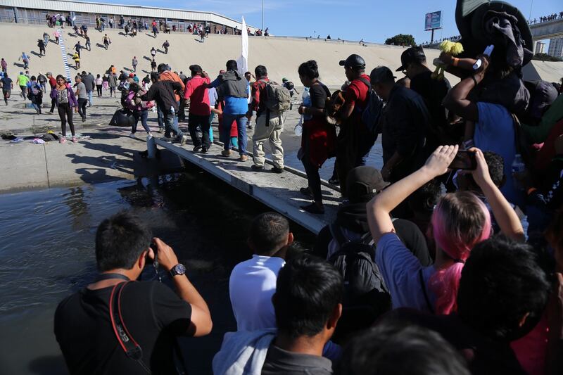 A group of people try to cross El Chaparral border crossing, in  Tijuana. A group of migrants from the caravan of central Americans who advanced today towards the San Ysidro (US) gateway deviated from the planned route to try to cross the border wall by other points, while the US border police threw tear gas. Photograph: David Guzman/EPA