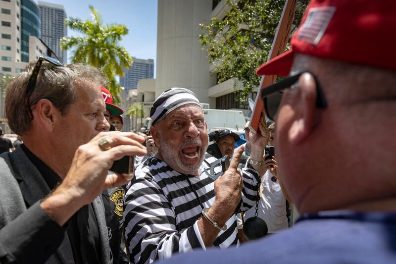 Domenic Santana  is surrounded by Trump supporters outside the Wilkie D Ferguson Jr US Courthouse in Miami. He said some members of his family have been caught up in the "Trump cult". Photograph: Christian Monterrosa/New York Times.
                      