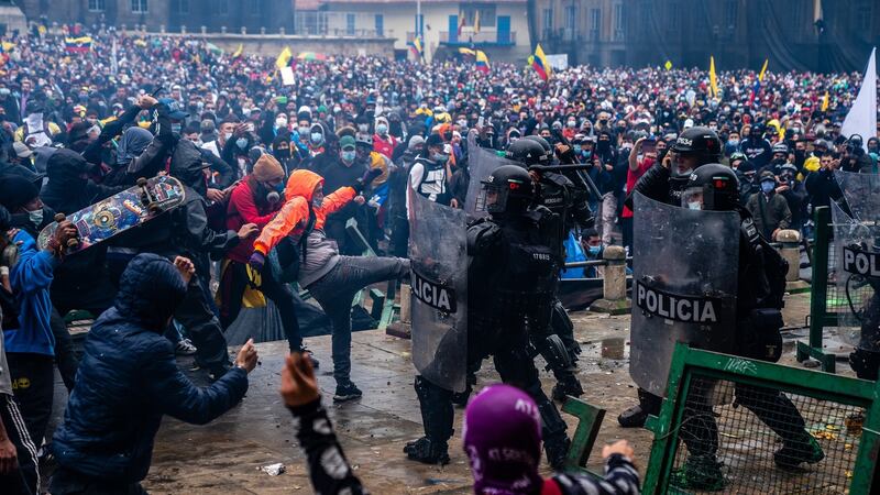 Demonstrators and police officers clash in Bogotá, Colombia during a protest against tax reform. Photograph: Federico Rios/The New York Times