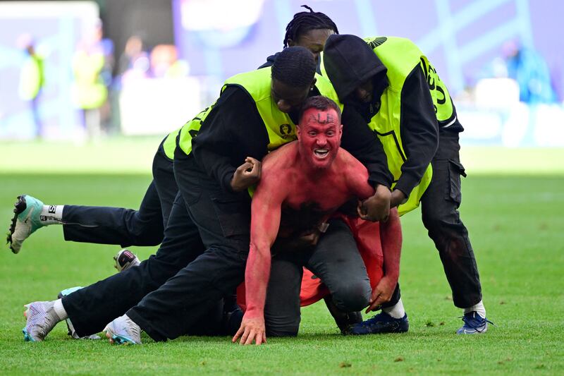 A pitch invader with the Albanian flag emblazoned on the chest is removed by stewards at the end of the match against Croatia. Photograph: John MacDougall/Getty Images