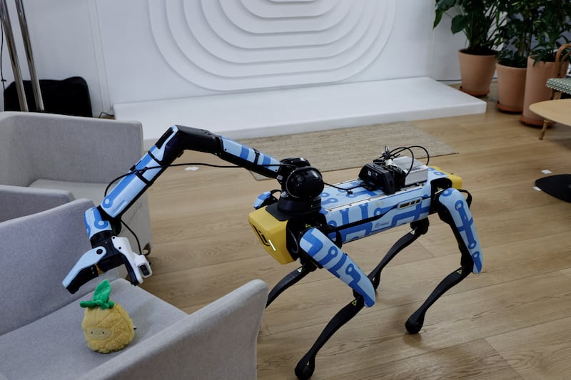 A robot dog called Spot, developed by Boston Dynamics, picks up an object during a demonstration at the Meta research laboratory in Paris earlier this month. Photograph: Stephane de Sakutin/AFP via Getty Images