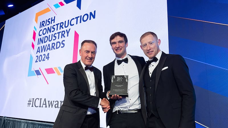 Ciaran Moody, branch president at Mitsubishi Electric, presents the engineering project of the year award to Adam Smyth and Adam Kenny, Jones Engineering Manufacturing