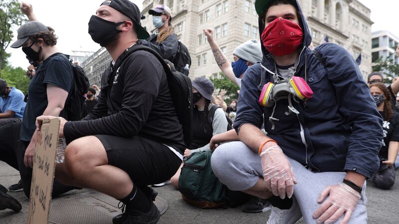 Demonstrators in Washington kneel during a protest against police brutality and the death of George Floyd for a fifth consecutive day ahead of a 7pm curfew. Photograph:  Alex Wong/Getty Images