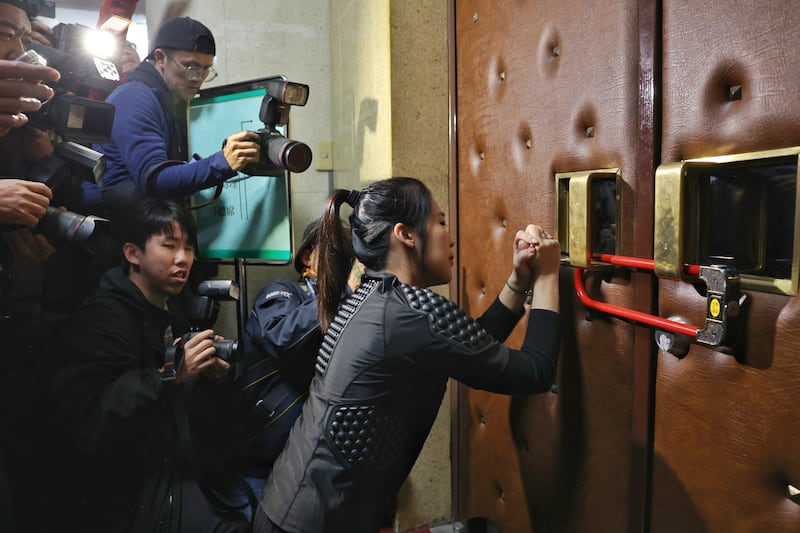 Taiwan opposition party Kuomintang (KMT) lawmaker Hsu Chiao-hsin tries to break the lock to the Parliament after the Democratic Progressive Party (DPP) lock themselves inside overnight over the third reading of amendments to the Civil Servants Election and Recall Act and other controversial bills at the Legislative Yuan in Taipei. Photograph: I-Hwa Cheng/AFP